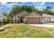 Traditional home with a two-car garage, healthy lawn, and decorative front garden at 6701 Belmar Dr, Orlando, FL 32807