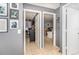 Hallway with doors to rooms, tile floors, and walls decorated with art and Gathering photos at 6701 Belmar Dr, Orlando, FL 32807