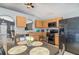 Eat-in kitchen with tile floor, black appliances and wooden cabinetry with ample counter space at 6701 Belmar Dr, Orlando, FL 32807