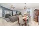 Open living room with dining area featuring tile floors, modern lighting, and comfortable seating at 6701 Belmar Dr, Orlando, FL 32807