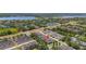 An aerial view showcases the community layout with a lake backdrop and well-maintained townhome residences at 7010 Broomshedge Trl, Winter Garden, FL 34787