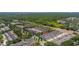 The aerial view highlights the townhomes with nearby green spaces and the contrast of the forest in the distance at 7010 Broomshedge Trl, Winter Garden, FL 34787