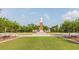 Picturesque view of the community clock tower situated on a lush green lawn with manicured landscaping at 7010 Broomshedge Trl, Winter Garden, FL 34787