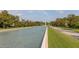 Captured is the tranquil community water feature leading to the clock tower, framed by manicured trees and pathways at 7010 Broomshedge Trl, Winter Garden, FL 34787