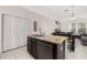 Kitchen island with granite countertop and sink, seamlessly connected to the living and dining areas at 7010 Broomshedge Trl, Winter Garden, FL 34787
