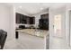 Stylish kitchen featuring dark wood cabinetry, a granite countertop island, and modern stainless steel appliances at 7010 Broomshedge Trl, Winter Garden, FL 34787