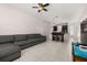 Spacious living room with tile flooring, an inviting gray couch, and an open layout to the kitchen at 7010 Broomshedge Trl, Winter Garden, FL 34787