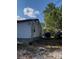 View of the side and back yard of the home, featuring trailer and vehicle at 7506 Mott Ave, Orlando, FL 32810
