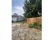 Image of an unkempt backyard featuring a weathered house, debris, and a newly installed wooden fence at 7506 Mott Ave, Orlando, FL 32810