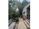 Exterior shot of a home's backyard with patio area, plantings, and mature trees at 7506 Mott Ave, Orlando, FL 32810