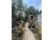 Exterior shot of a backyard featuring outdoor seating, a grill, and a lush garden at 7506 Mott Ave, Orlando, FL 32810