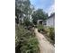 Photo of an overgrown backyard featuring garden furniture, plants, a pathway, and the home's exterior at 7506 Mott Ave, Orlando, FL 32810