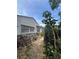 Exterior shot of the house's rear, showcasing greenery, stone accents, and bicycle storage at 7506 Mott Ave, Orlando, FL 32810