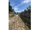A long, narrow driveway is enclosed by wooden fences on either side, leading towards the street at 7506 Mott Ave, Orlando, FL 32810