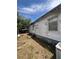 A shot of the home's exterior with its faded white siding and overgrown landscaping at 7506 Mott Ave, Orlando, FL 32810