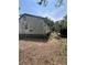 Shot of the rear of the home with faded siding and an unkempt yard at 7506 Mott Ave, Orlando, FL 32810