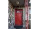 Inviting stone-clad entrance with a striking red door and decorative security door showcasing curb appeal at 7506 Mott Ave, Orlando, FL 32810