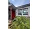 Quaint home featuring a red front door, stone details, and large windows at 7506 Mott Ave, Orlando, FL 32810
