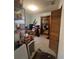 Cluttered living room featuring shelving, doorway, and poor carpet at 7506 Mott Ave, Orlando, FL 32810
