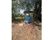 A blue water pressure tank and pump are installed outside beneath some trees on a bed of leaves at 7506 Mott Ave, Orlando, FL 32810