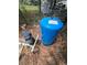 A blue water pressure tank and pump are installed outside on a bed of leaves near a fence at 7506 Mott Ave, Orlando, FL 32810
