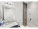 Bathroom featuring walk-in shower, white sink, and neutral gray tiling at 8210 Topsail Pl, Winter Garden, FL 34787