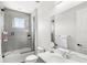 Bright bathroom featuring shower and tub combo, white sink, and neutral gray tiling at 8210 Topsail Pl, Winter Garden, FL 34787
