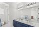Bathroom featuring double sink vanity, blue cabinets, and separate shower and tub at 8210 Topsail Pl, Winter Garden, FL 34787