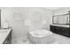 Spa-like main bathroom featuring a soaking tub, dual vanities, and marble tile at 8210 Topsail Pl, Winter Garden, FL 34787