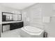 Elegant main bathroom boasts a large soaking tub, dual sinks, and a window at 8210 Topsail Pl, Winter Garden, FL 34787