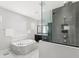 Bright bathroom features a glass shower, soaking tub and modern fixtures at 8210 Topsail Pl, Winter Garden, FL 34787