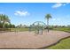 Outdoor playground equipment on wood chips surface with palm trees in the background at 8210 Topsail Pl, Winter Garden, FL 34787