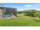 A screened-in patio and pool overlook the sprawling backyard and lake at 850 Spring Oak Cir, Orlando, FL 32828
