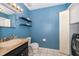 Bathroom with blue walls, updated fixtures, and a washing machine at 9316 Dubois Blvd, Orlando, FL 32825