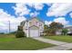 Two-story home with light beige siding, attached garage, and well-maintained lawn under a sunny, partly cloudy sky at 9316 Dubois Blvd, Orlando, FL 32825