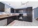 Functional kitchen with dark cabinetry, stainless steel appliances, and tile flooring; ready for culinary adventures at 9316 Dubois Blvd, Orlando, FL 32825