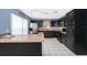 Beautiful kitchen boasts dark cabinets, stainless steel appliances, an island, and tiled floors, great for cooking at 9316 Dubois Blvd, Orlando, FL 32825