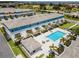 Aerial view showcasing townhouse exteriors, community pool, pool house, outdoor seating, and landscaped grounds at 960 Golden Bear Dr, Reunion, FL 34747