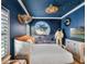 Space-themed bedroom featuring a custom bed, mural, ceiling fan, and decor at 960 Golden Bear Dr, Reunion, FL 34747