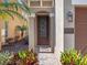 Charming entryway with a decorative front door, stone columns, and manicured landscaping at 960 Golden Bear Dr, Reunion, FL 34747
