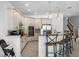 Contemporary kitchen featuring white cabinets, stainless steel appliances, and a central island with bar stools at 960 Golden Bear Dr, Reunion, FL 34747