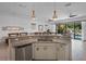 Kitchen view showcasing granite countertops, modern cabinetry, and a view of the living area and pool at 960 Golden Bear Dr, Reunion, FL 34747