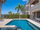 Luxury home backyard pool and spa with elegant patio furniture and lush tropical landscaping at 960 Golden Bear Dr, Reunion, FL 34747