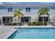 Relaxing pool area with clear blue water, manicured landscaping, palm trees, and private patios for tranquil outdoor living at 960 Golden Bear Dr, Reunion, FL 34747