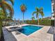 Serene backyard pool with lake view, patio furniture, and lush landscaping, perfect for relaxing at 960 Golden Bear Dr, Reunion, FL 34747
