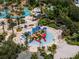 Aerial view of a community water park with pools, slides, and lounging areas surrounded by lush landscaping at 960 Golden Bear Dr, Reunion, FL 34747