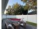 Serene backyard featuring a brick patio, a white fence, and a pink hammock, perfect for enjoying outdoor activities at 9959 Cypress Vine Dr, Orlando, FL 32827
