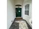 Close-up of a green front door with decorative accents and a welcome mat on a paved walkway at 9959 Cypress Vine Dr, Orlando, FL 32827