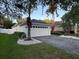 A view of a single-story home featuring a paved driveway, well-maintained landscaping, and white exterior walls at 9959 Cypress Vine Dr, Orlando, FL 32827