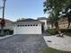 Charming single-story home featuring a well-manicured front yard with a paved driveway and a two-car garage at 9959 Cypress Vine Dr, Orlando, FL 32827